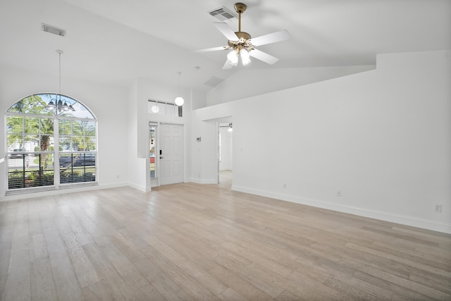 1633 SE Clearmont St, Port Saint Lucie, FL 34983 - unfurnished living room featuring light wood-style floors, a chandelier, a ceiling fan, and high vaulted ceiling