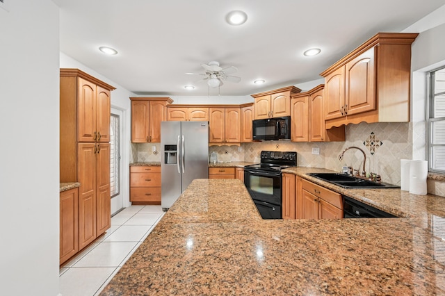 7 Greenway N Unit 111, Royal Palm Beach, FL 33411 - kitchen with black appliances, a ceiling fan, light stone counters, tasteful backsplash, and light tile patterned flooring