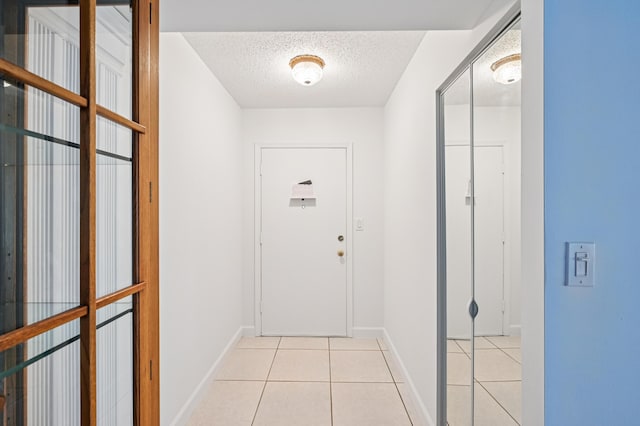 7 Greenway N Unit 111, Royal Palm Beach, FL 33411 - doorway to outside with a textured ceiling and light tile patterned floors