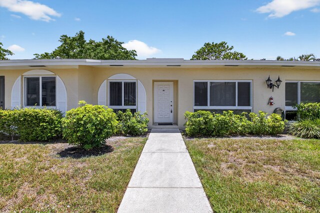 13984 Via Flora Unit B, Delray Beach, FL 33484 - view of front of home with stucco siding and a front yard
