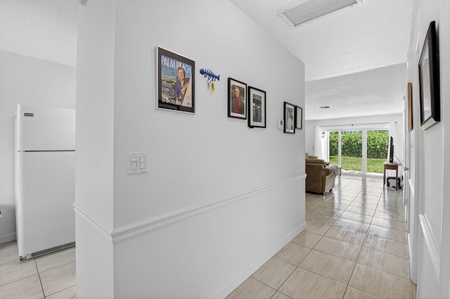 13984 Via Flora Unit B, Delray Beach, FL 33484 - hallway featuring a textured ceiling and light tile patterned floors