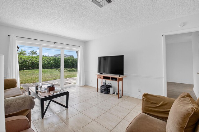 13984 Via Flora Unit B, Delray Beach, FL 33484 - living room featuring a textured ceiling and light tile patterned floors