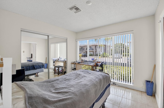 13984 Via Flora Unit B, Delray Beach, FL 33484 - bedroom featuring tile patterned floors, a closet, a textured ceiling, and access to outside