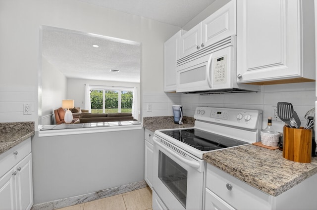 13984 Via Flora Unit B, Delray Beach, FL 33484 - kitchen featuring white appliances, a textured ceiling, white cabinets, open floor plan, and tasteful backsplash