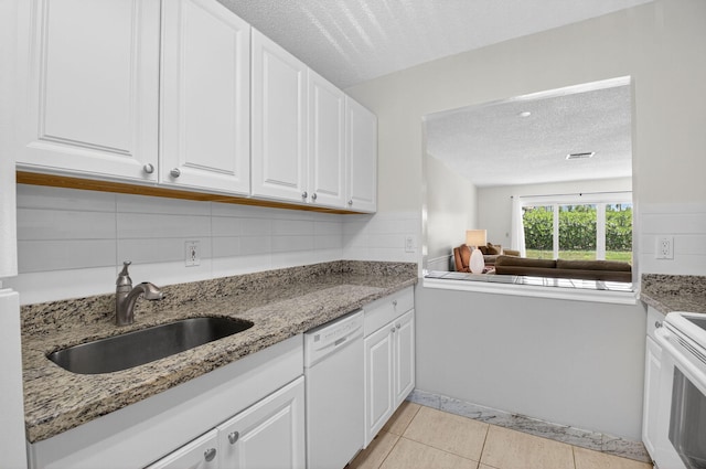13984 Via Flora Unit B, Delray Beach, FL 33484 - kitchen featuring white appliances, a textured ceiling, white cabinets, light tile patterned floors, and light stone counters