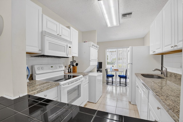 13984 Via Flora Unit B, Delray Beach, FL 33484 - kitchen featuring white appliances, white cabinets, a textured ceiling, light tile patterned floors, and backsplash
