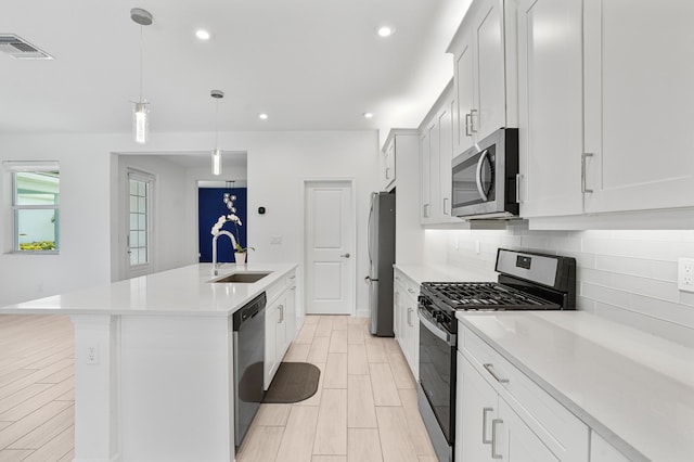 11687 SW Viridian Blvd, Port Saint Lucie, FL 34987 - kitchen featuring stainless steel appliances, a center island with sink, light countertops, decorative backsplash, and recessed lighting