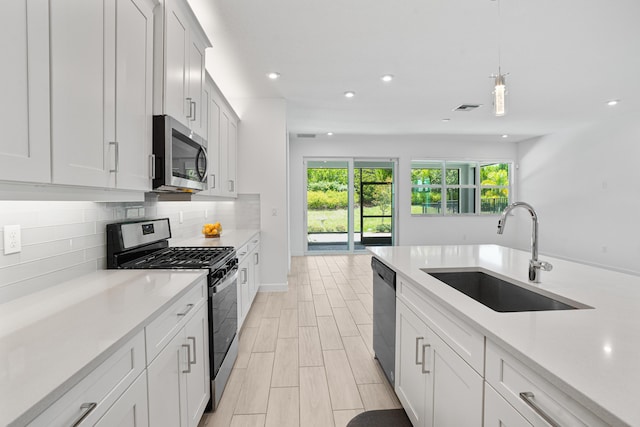 11687 SW Viridian Blvd, Port Saint Lucie, FL 34987 - kitchen featuring appliances with stainless steel finishes, recessed lighting, light countertops, decorative backsplash, and hanging light fixtures