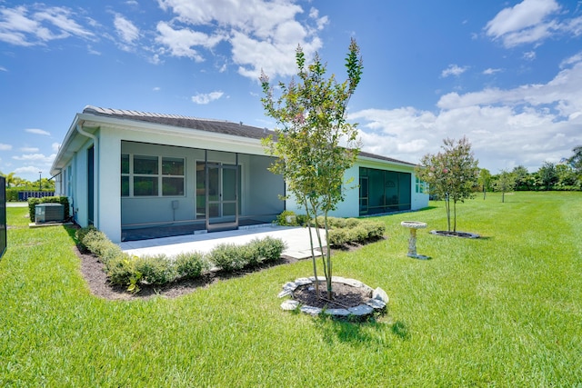 11687 SW Viridian Blvd, Port Saint Lucie, FL 34987 - rear view of house featuring a sunroom, a lawn, and stucco siding