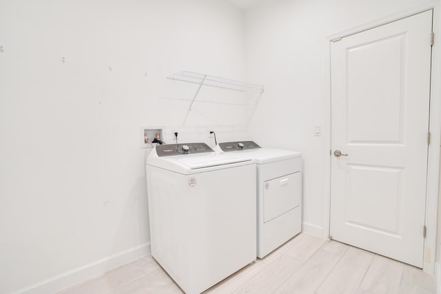 11687 SW Viridian Blvd, Port Saint Lucie, FL 34987 - washroom featuring washing machine and dryer and light wood-style flooring