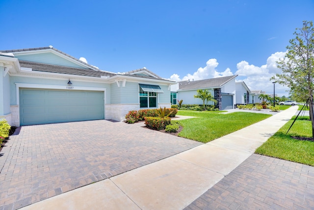 11687 SW Viridian Blvd, Port Saint Lucie, FL 34987 - ranch-style house with a front yard, a tiled roof, decorative driveway, and an attached garage