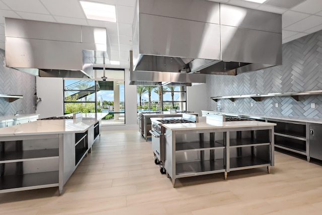 11687 SW Viridian Blvd, Port Saint Lucie, FL 34987 - kitchen featuring open shelves, backsplash, stainless steel range, wall chimney range hood, and a drop ceiling