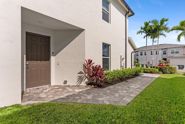 6161 Rancho Ln, West Palm Beach, FL 33415 - doorway to property with stucco siding and a yard