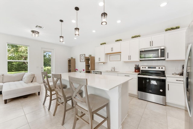 6161 Rancho Ln, West Palm Beach, FL 33415 - kitchen featuring appliances with stainless steel finishes, backsplash, light countertops, light tile patterned floors, and recessed lighting