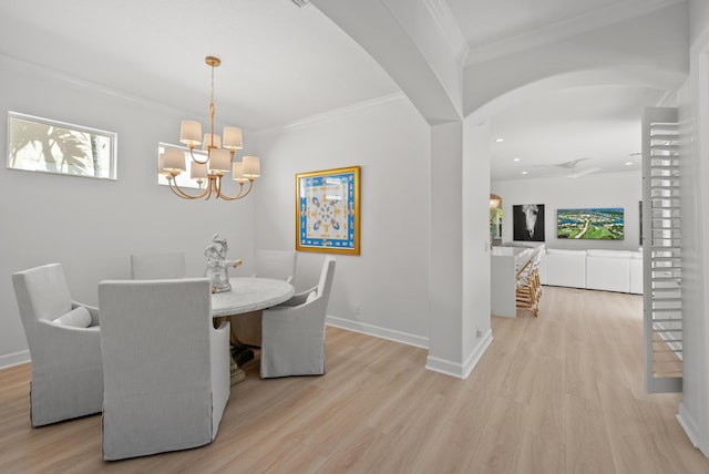 12025 Aviles Cir, Palm Beach Gardens, FL 33418 - dining space with arched walkways, a chandelier, plenty of natural light, light wood-style floors, and crown molding