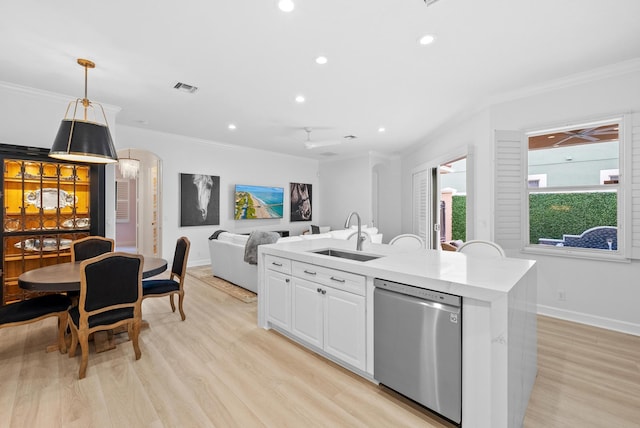 12025 Aviles Cir, Palm Beach Gardens, FL 33418 - kitchen with stainless steel dishwasher, ornamental molding, a center island with sink, light countertops, and light wood-type flooring