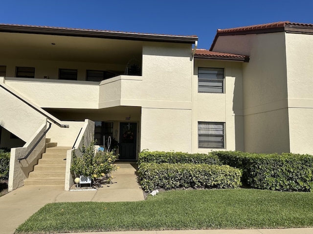 5807 Parkwalk Dr Unit 1124, Boynton Beach, FL 33472 - entrance to property featuring stucco siding, a balcony, a tile roof, and a yard
