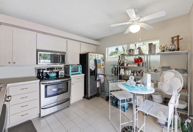 4604 Roxbury Ct, Boynton Beach, FL 33436 - kitchen with stainless steel appliances, light tile patterned floors, ceiling fan, light countertops, and a textured ceiling