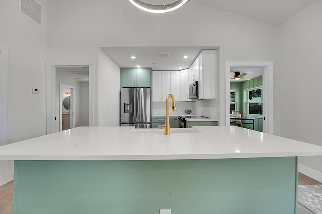950 York St, West Palm Beach, FL 33401 - kitchen featuring stainless steel appliances, light wood finished floors, light countertops, white cabinets, and lofted ceiling
