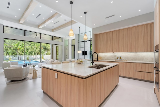 2265 NE 30th Ct, Lighthouse Point, FL 33064 - kitchen featuring modern cabinets, open floor plan, light brown cabinets, tasteful backsplash, and a spacious island