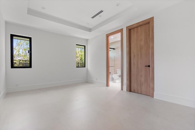 2265 NE 30th Ct, Lighthouse Point, FL 33064 - unfurnished bedroom with a raised ceiling, multiple windows, and connected bathroom