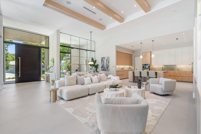 2265 NE 30th Ct, Lighthouse Point, FL 33064 - living room featuring a towering ceiling, beam ceiling, healthy amount of natural light, and finished concrete floors