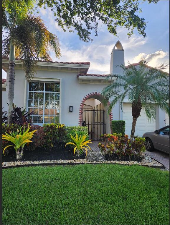 8045 NW 109th Ln, Parkland, FL 33076 - view of front facade featuring stucco siding, a front lawn, and an attached garage