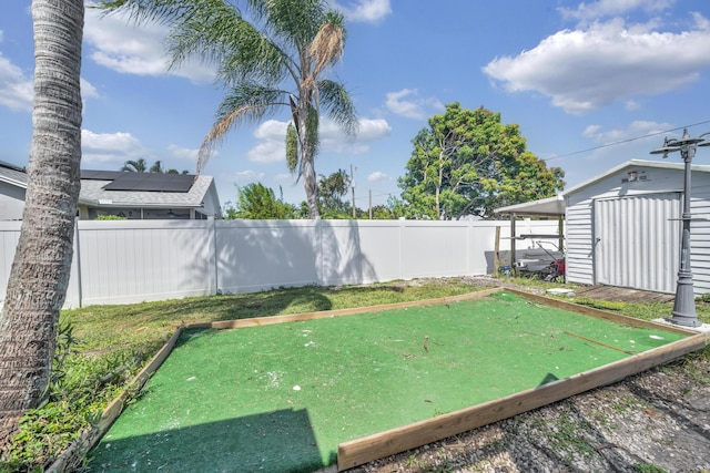 356 SW Grimaldo Ter, Port Saint Lucie, FL 34984 - fenced backyard featuring a bocce ball area and a storage unit