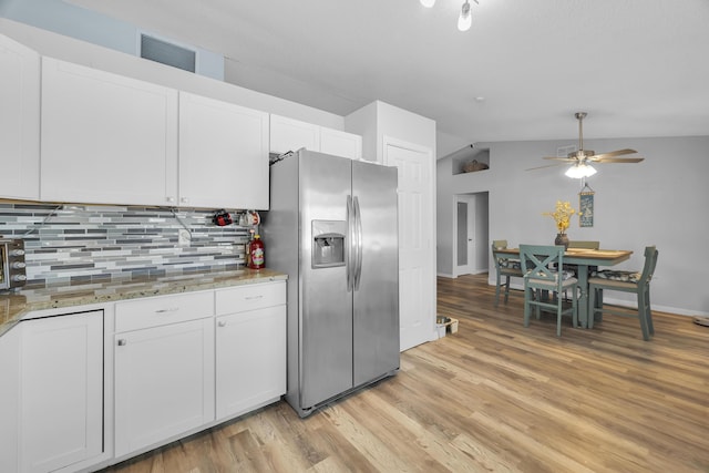 356 SW Grimaldo Ter, Port Saint Lucie, FL 34984 - kitchen with stainless steel refrigerator with ice dispenser, vaulted ceiling, decorative backsplash, light wood finished floors, and white cabinets