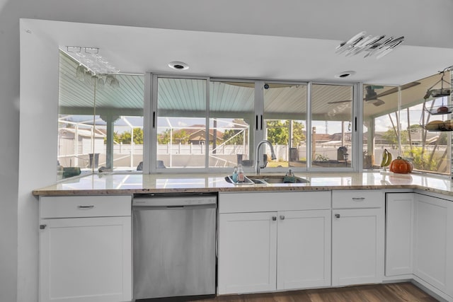 356 SW Grimaldo Ter, Port Saint Lucie, FL 34984 - kitchen with stainless steel dishwasher, white cabinetry, light stone counters, and wood finished floors