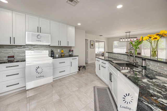 1518 Lee Ct, Lake Worth, FL 33461 - kitchen with white microwave, range, tasteful backsplash, recessed lighting, and white cabinetry
