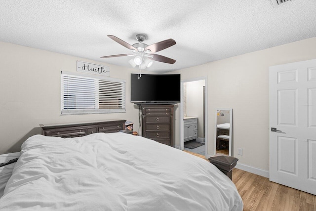 18 Winchmore Ln, Boynton Beach, FL 33426 - bedroom with light wood-style flooring, a textured ceiling, a ceiling fan, and ensuite bathroom