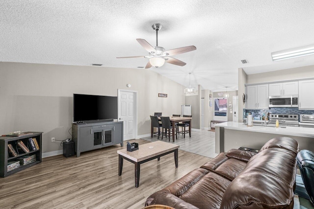 18 Winchmore Ln, Boynton Beach, FL 33426 - living area featuring light wood-style flooring, a textured ceiling, ceiling fan, and lofted ceiling