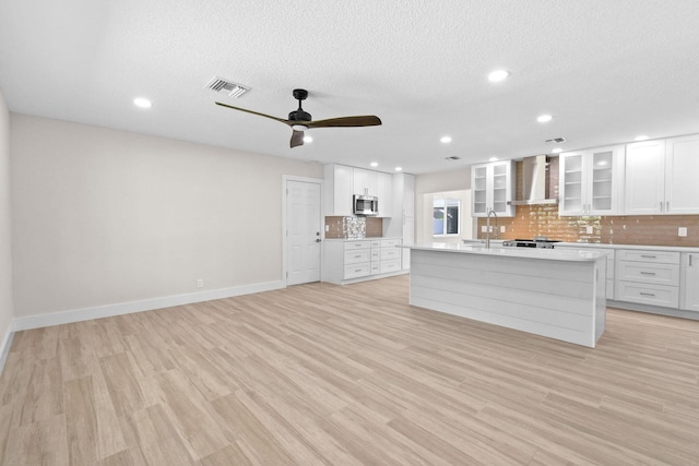 1522 Lance Rd, Jupiter, FL 33469 - kitchen with wall chimney exhaust hood, stainless steel microwave, backsplash, light countertops, and ceiling fan