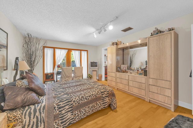 9070 NW 16th St, Plantation, FL 33322 - bedroom with light wood-type flooring and a textured ceiling