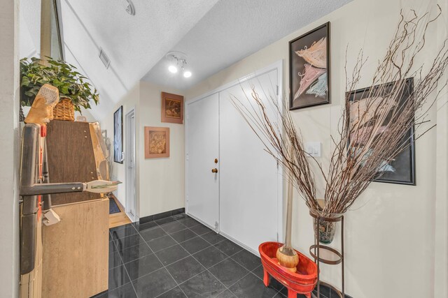9070 NW 16th St, Plantation, FL 33322 - foyer entrance featuring dark tile patterned flooring and a textured ceiling