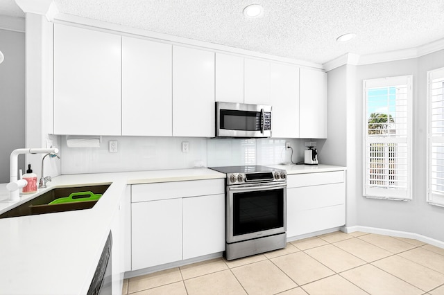 5086 Prairie Dunes Village Cir, Lake Worth, FL 33463 - kitchen featuring stainless steel appliances, backsplash, a textured ceiling, light countertops, and white cabinets
