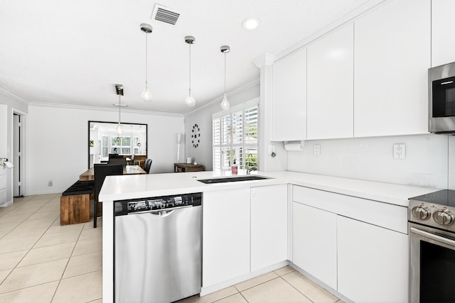 5086 Prairie Dunes Village Cir, Lake Worth, FL 33463 - kitchen with stainless steel appliances, ornamental molding, a peninsula, light tile patterned flooring, and plenty of natural light