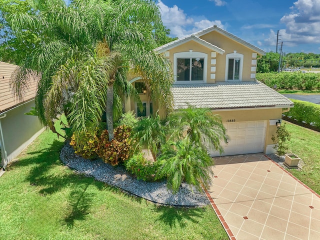 10889 Fillmore Dr, Boynton Beach, FL 33437 - view of front of home with a tiled roof, driveway, a garage, a front lawn, and stucco siding
