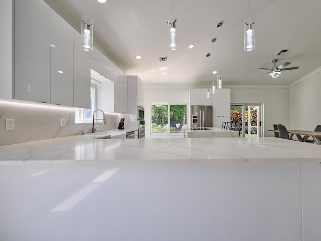 10889 Fillmore Dr, Boynton Beach, FL 33437 - kitchen with appliances with stainless steel finishes, modern cabinets, ornamental molding, white cabinetry, and healthy amount of natural light