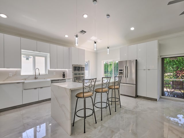 10889 Fillmore Dr, Boynton Beach, FL 33437 - kitchen with appliances with stainless steel finishes, modern cabinets, a kitchen breakfast bar, a center island, and light marble finish flooring