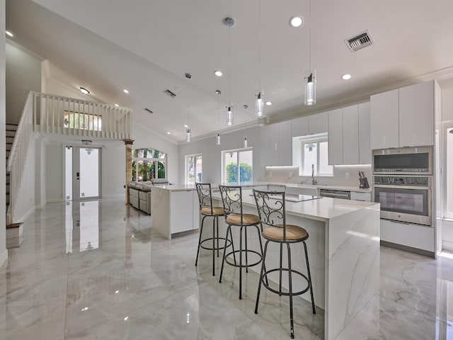 10889 Fillmore Dr, Boynton Beach, FL 33437 - kitchen featuring appliances with stainless steel finishes, light marble finish flooring, a kitchen island, modern cabinets, and ornamental molding