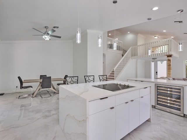 10889 Fillmore Dr, Boynton Beach, FL 33437 - kitchen featuring wine cooler, black electric stovetop, light marble finish flooring, crown molding, and a kitchen island