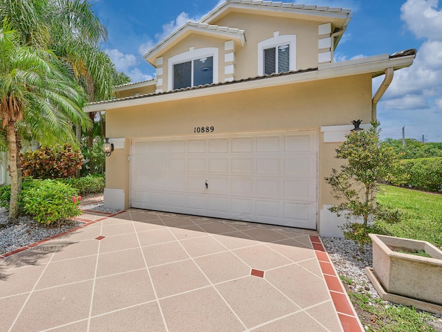 10889 Fillmore Dr, Boynton Beach, FL 33437 - view of front facade featuring stucco siding, a garage, and concrete driveway