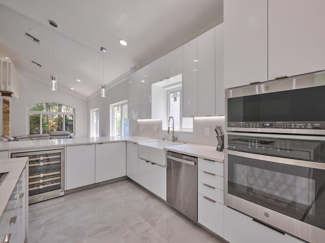 10889 Fillmore Dr, Boynton Beach, FL 33437 - kitchen featuring appliances with stainless steel finishes, beverage cooler, white cabinetry, lofted ceiling, and light marble finish flooring