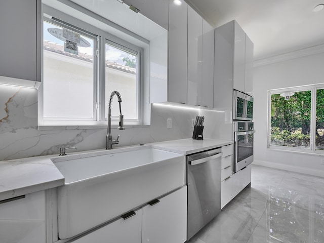 10889 Fillmore Dr, Boynton Beach, FL 33437 - kitchen with stainless steel appliances, modern cabinets, light marble finish floors, tasteful backsplash, and ornamental molding