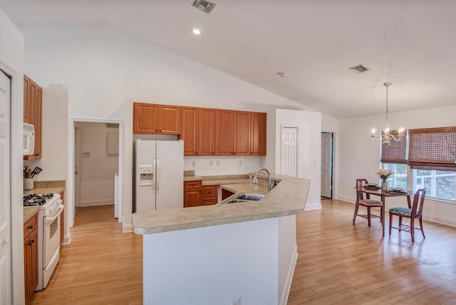 15213 N 93rd St, The Acreage, FL 33412 - kitchen with white appliances, light countertops, a chandelier, brown cabinets, and high vaulted ceiling