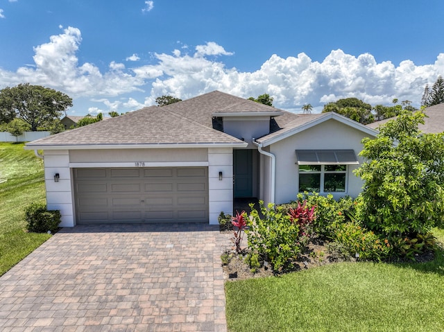 1878 NE Ocean Dunes Dr, Jensen Beach, FL 34957 - ranch-style home with roof with shingles, an attached garage, decorative driveway, a front yard, and stucco siding