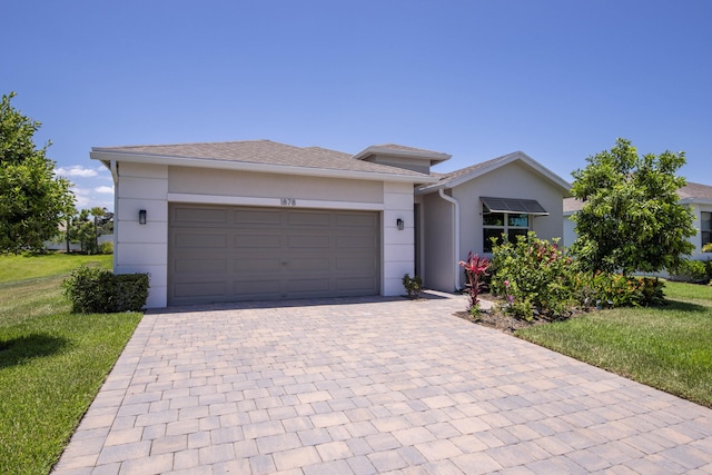 1878 NE Ocean Dunes Dr, Jensen Beach, FL 34957 - view of front facade featuring decorative driveway, an attached garage, a front yard, and stucco siding