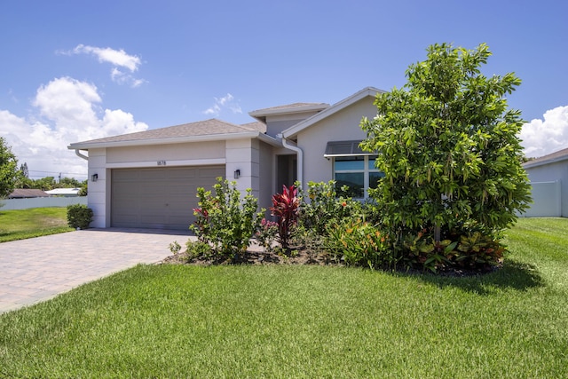 1878 NE Ocean Dunes Dr, Jensen Beach, FL 34957 - view of front of house featuring a garage, stucco siding, decorative driveway, and a front lawn